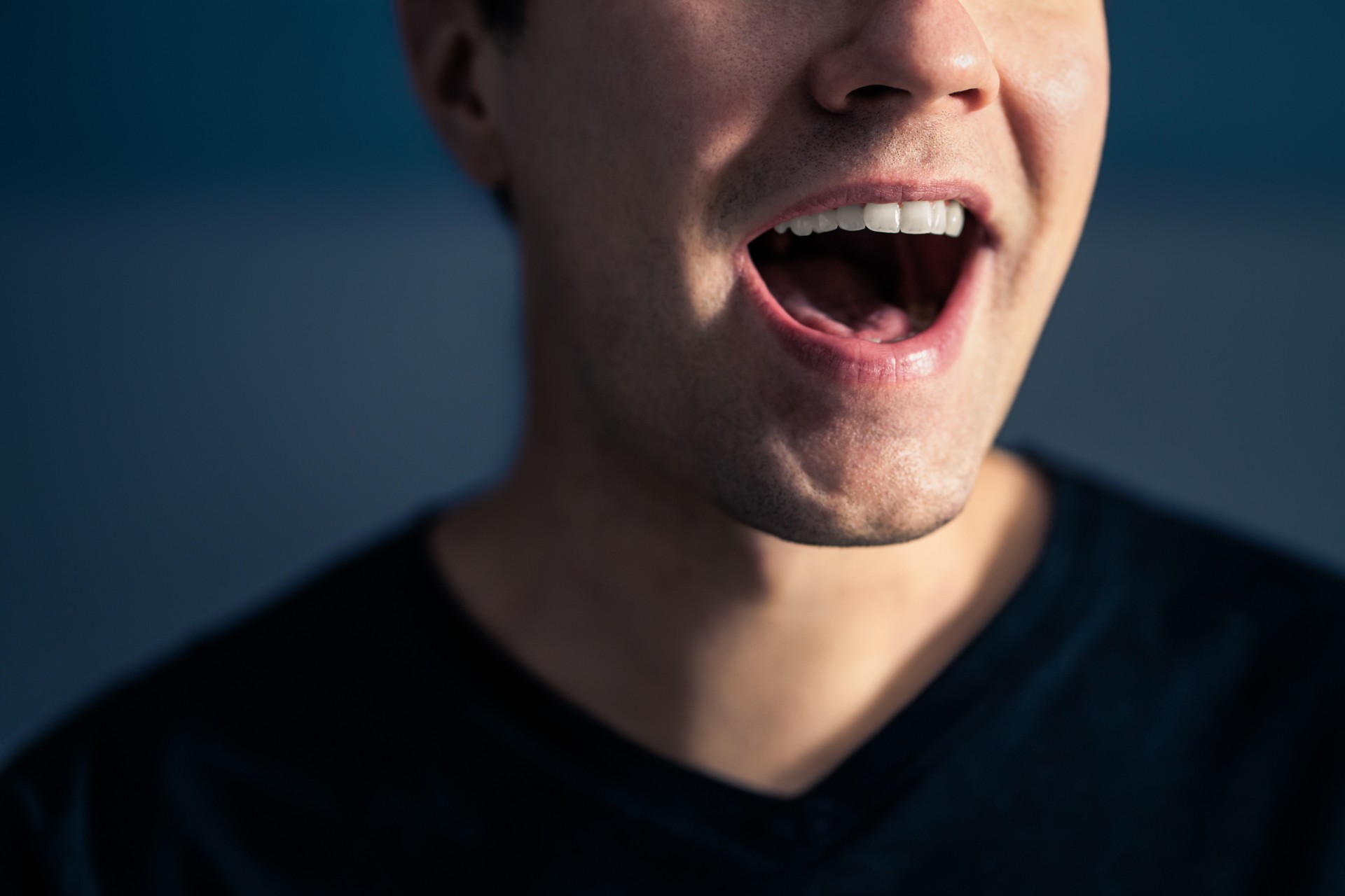 Singen, reden oder sprechen. Sänger mit offenem Mund. Mann mit lautem Klang der Stimme. Aussprache im Sprachunterricht, in der Artikulationsübung oder im Gesangsunterricht. Lied im Musikstudio. Rede oder Karaoke.